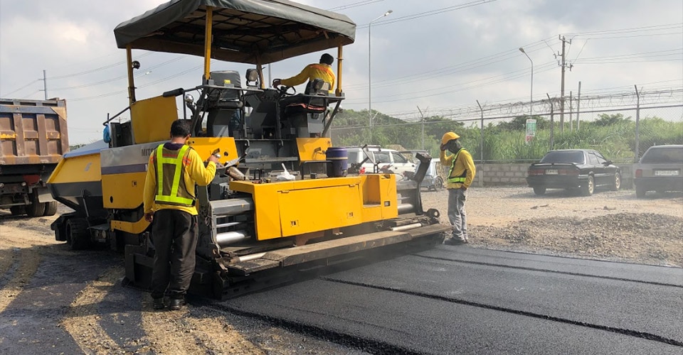 construction crew lays road that utilizes recycled plastic